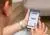 Jonge man bekijkt app reuma op een mobiele telefoon