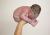 Een pasgeboren baby, hooggehouden in de hand