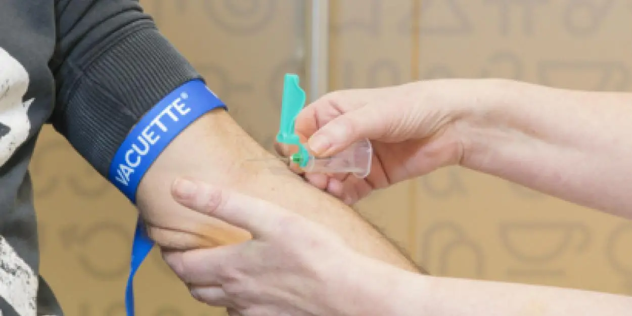 Een arm waarin wordt geprikt voor bloedafname