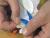 Twee handen maken de beschermlaag van de Nefrodrain pleister los